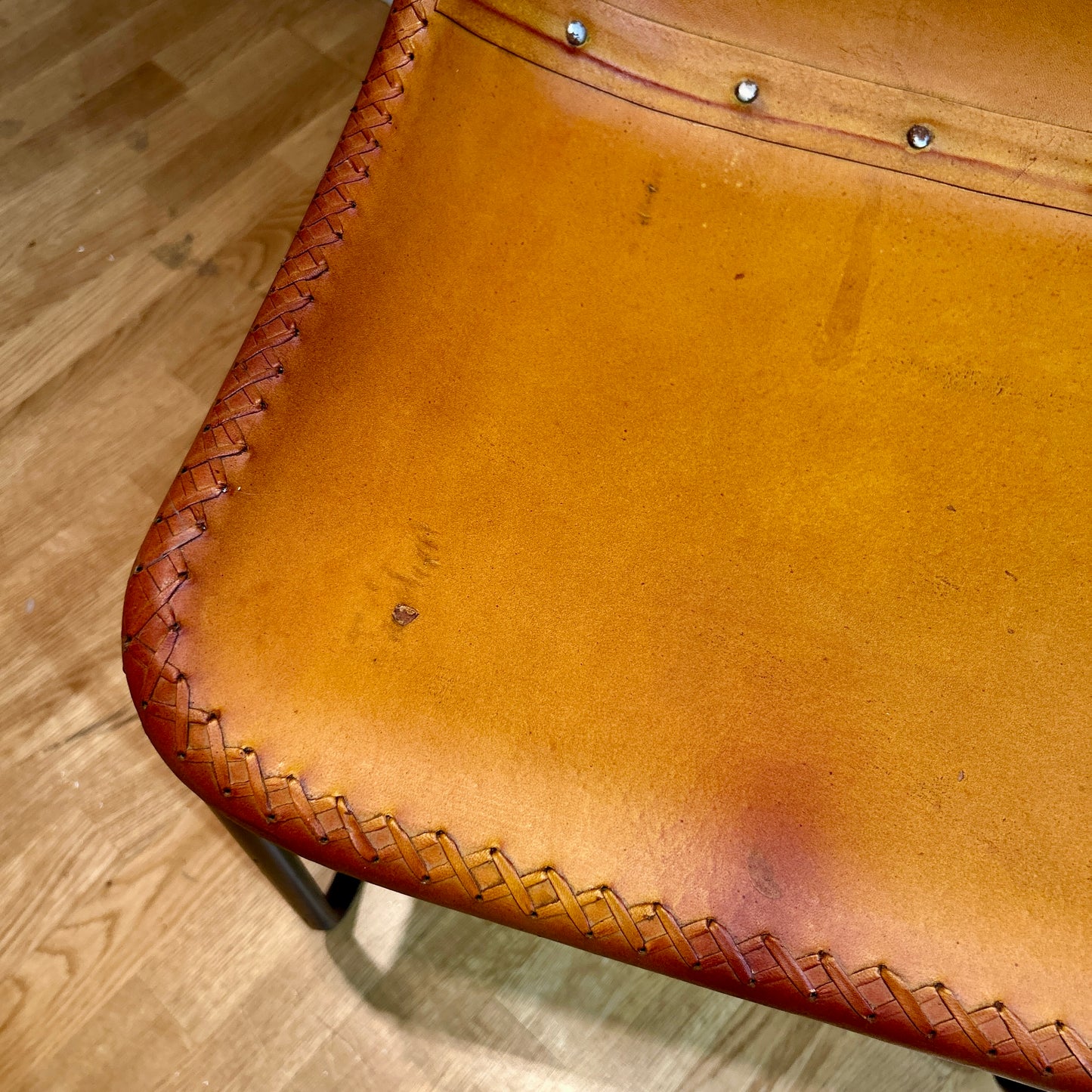 Leather covered chairs with braided edge detail